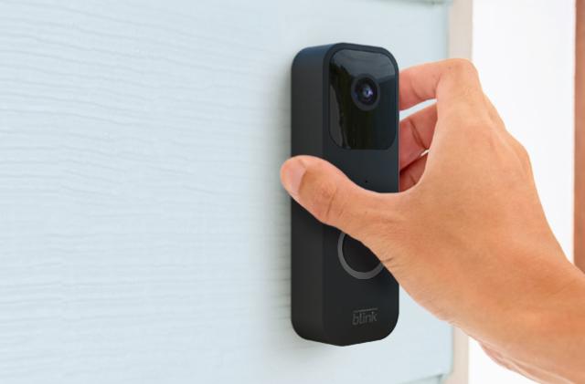 The Blink video doorbell is being installed wirelessly on a house to the side of the front door.  